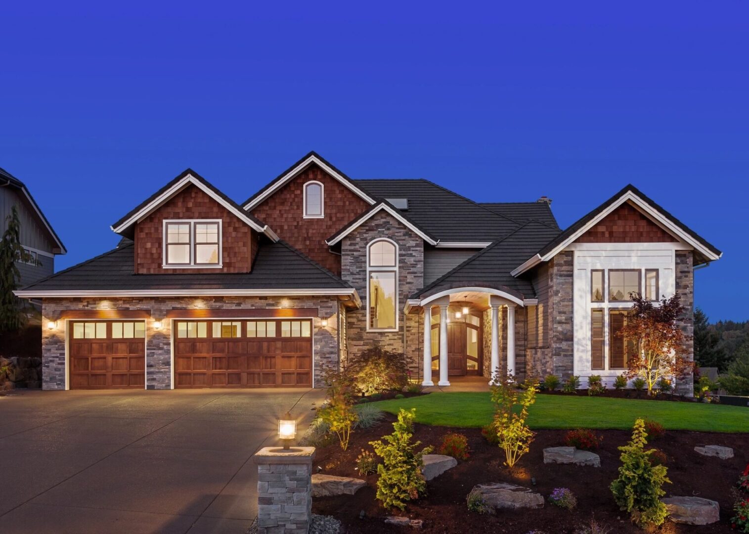 A large house with a driveway and lawn.