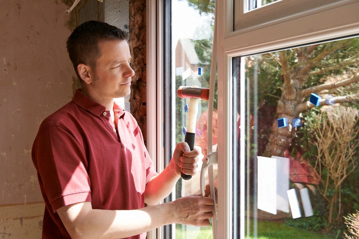 A man in red shirt holding a window.