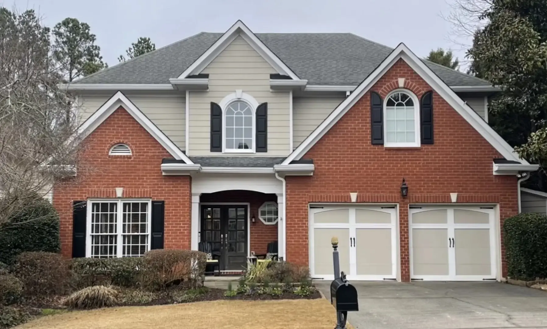 A large brick house with two garage doors.